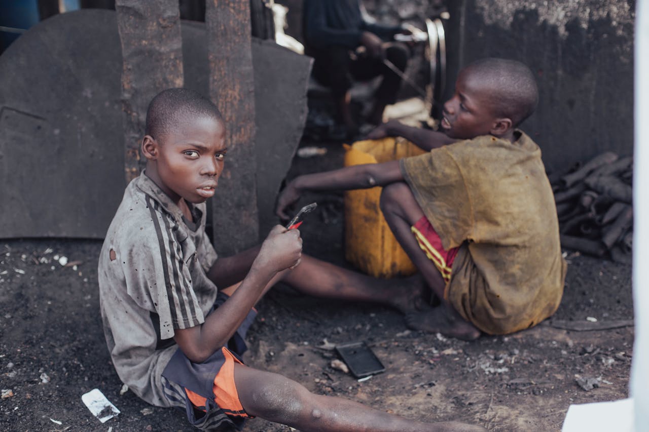 Services-03 Two children working with tools in a rustic environment, illustrating child labor and hardships.
